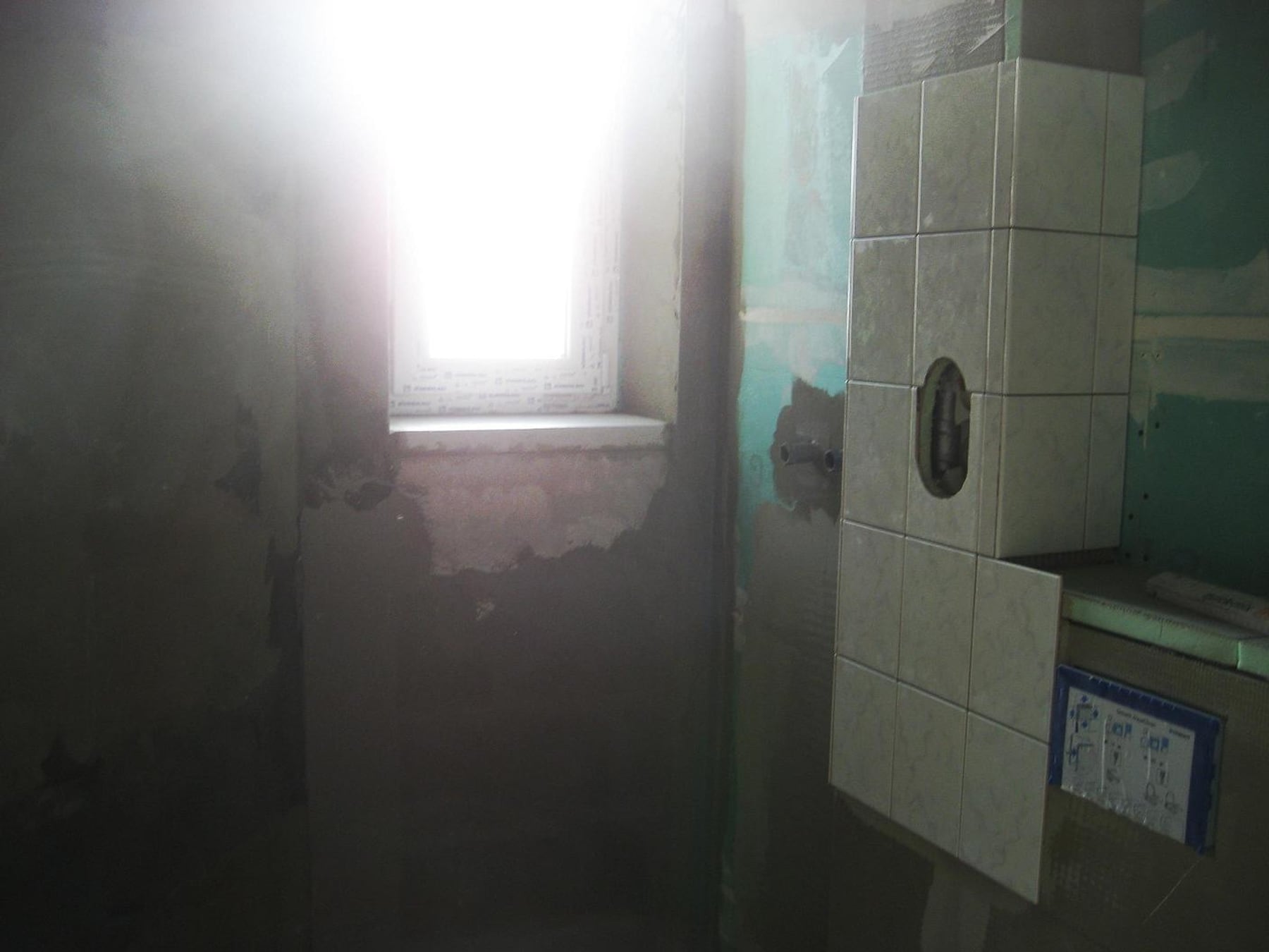 Baustelle Bad mit frisch verlegten Fliesen und Fenster