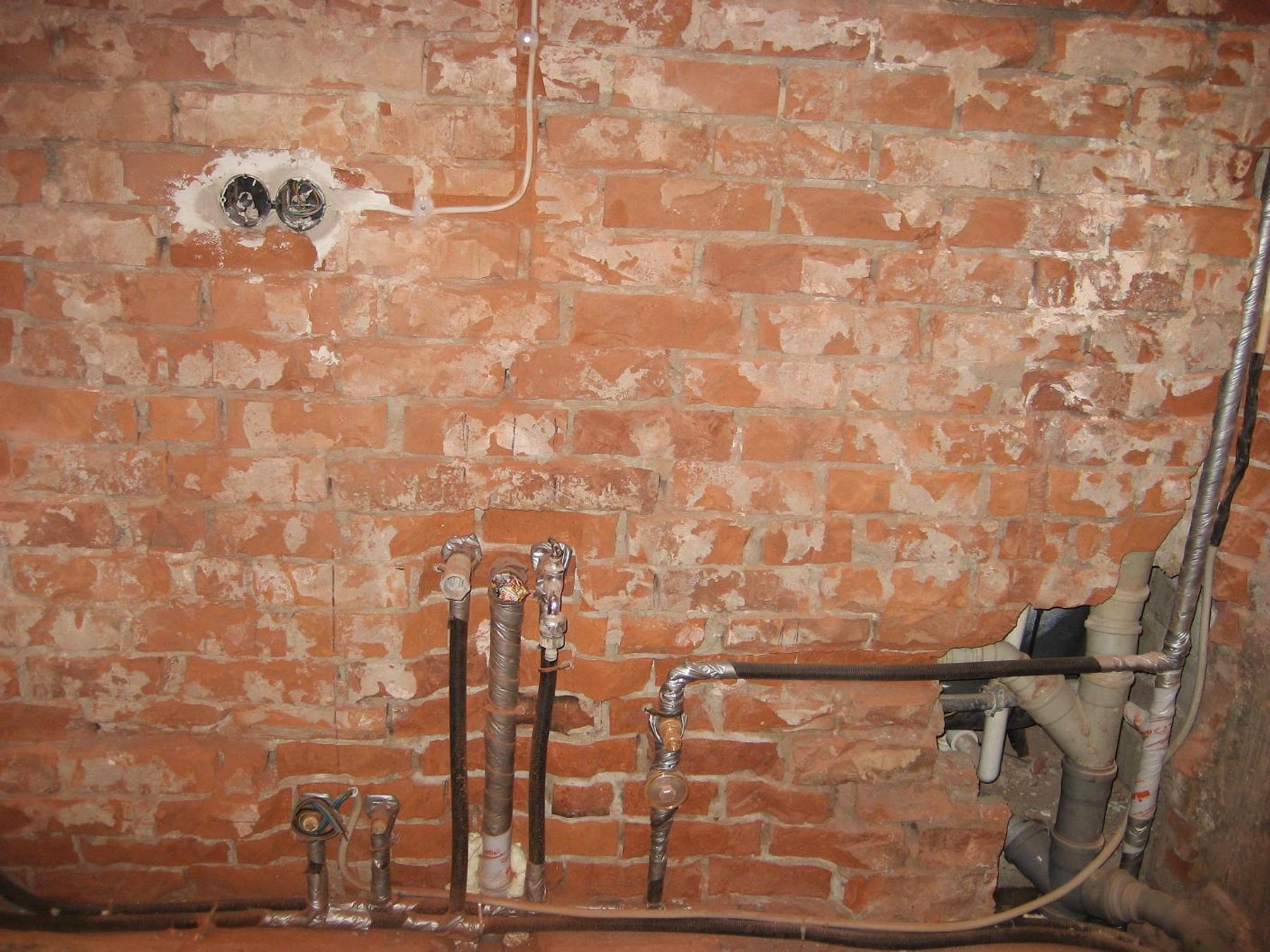 Rohinstallation Leitungen an Ziegelwand vor Fliesenarbeiten