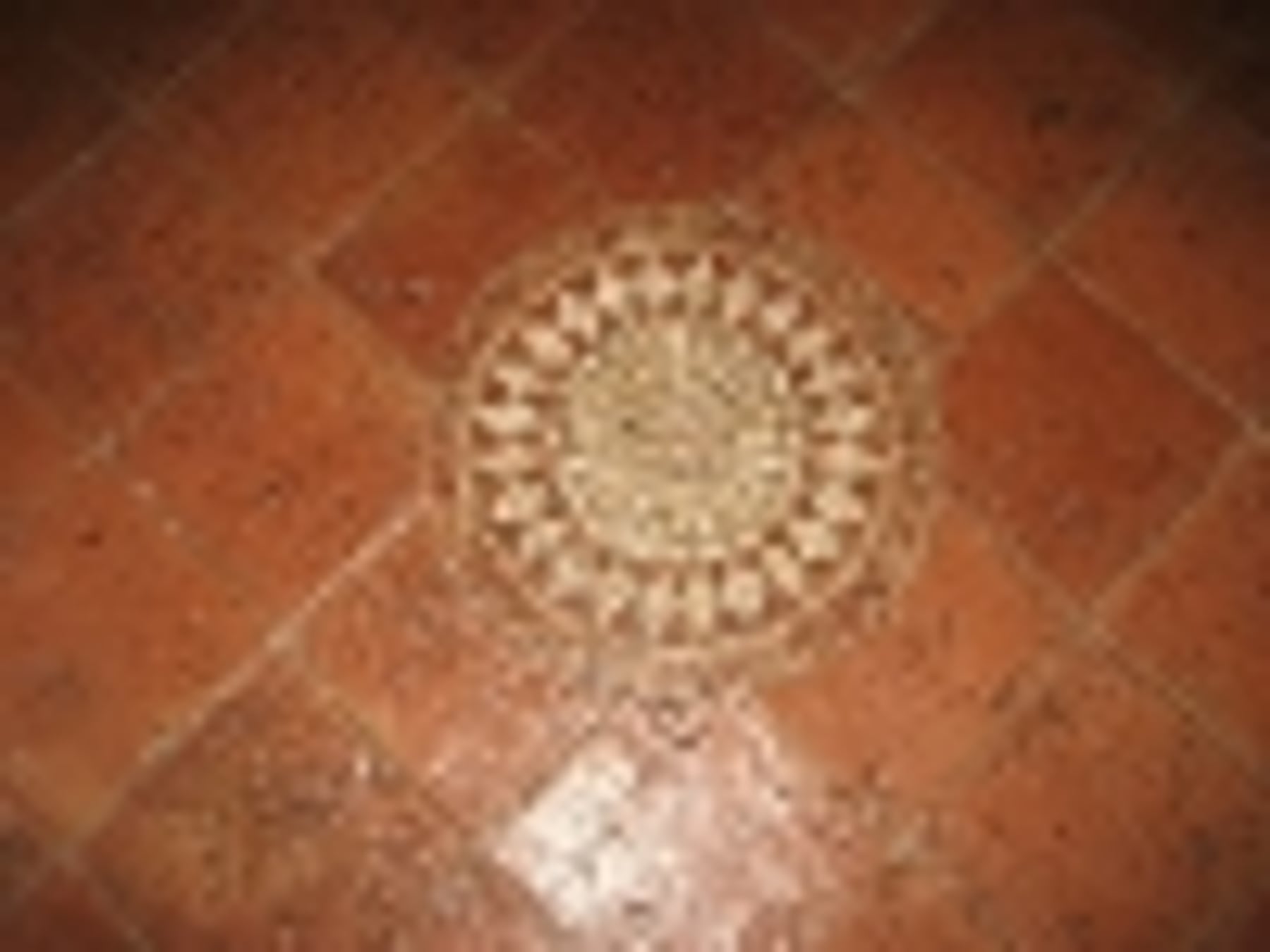 Terrakotta-Fliesenboden mit rundem Ornament-Mosaik